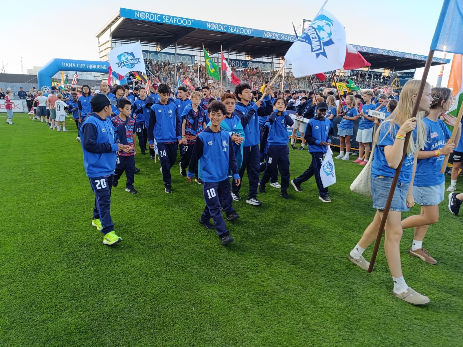 Jugadores de La Academia desfilan con su bandera durante la inauguración de un torneo internacional.