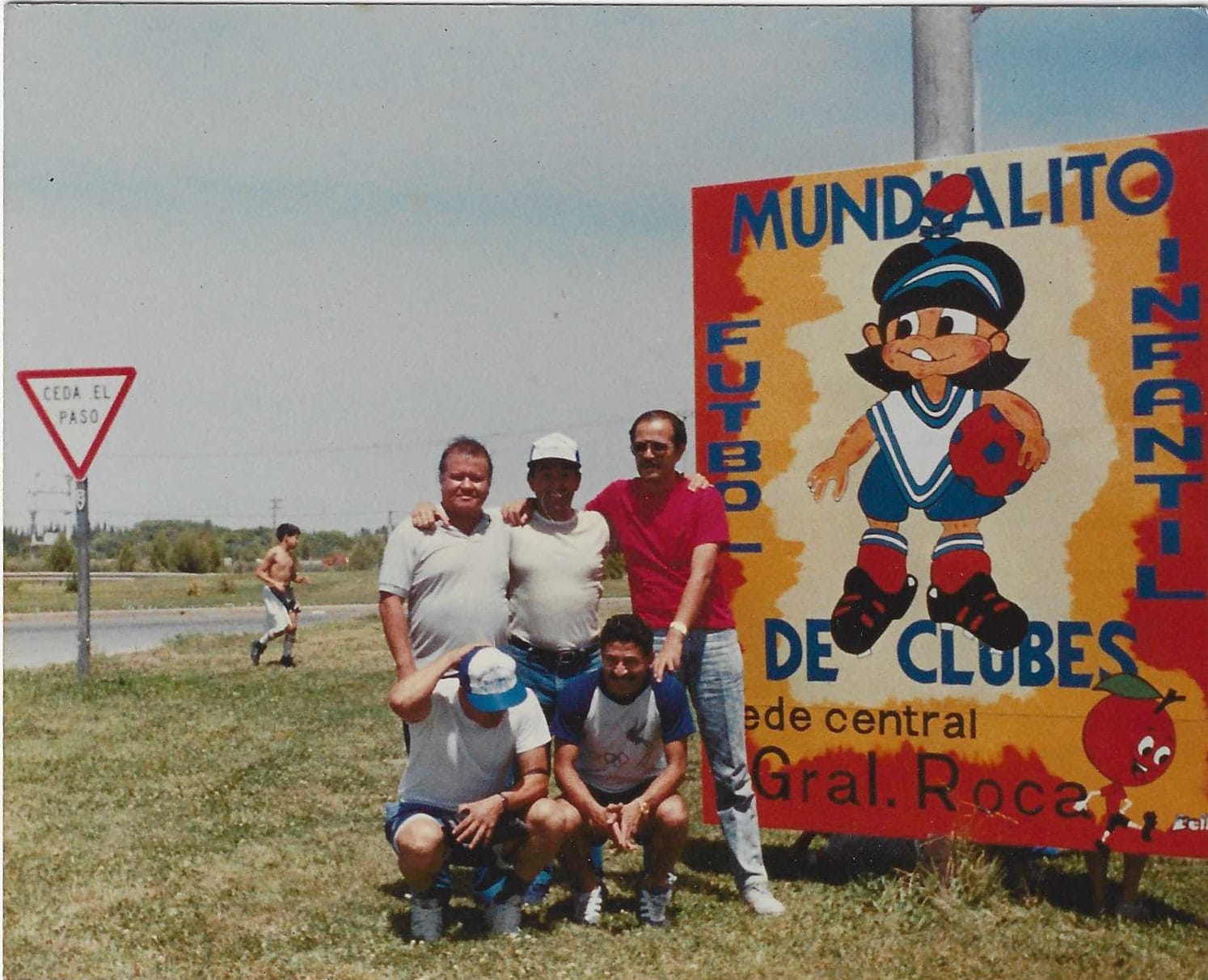 Entrenadores junto al cartel del Mundialito de Fútbol Infantil de Clubes, sede central General Roca, en Río Negro, Argentina.