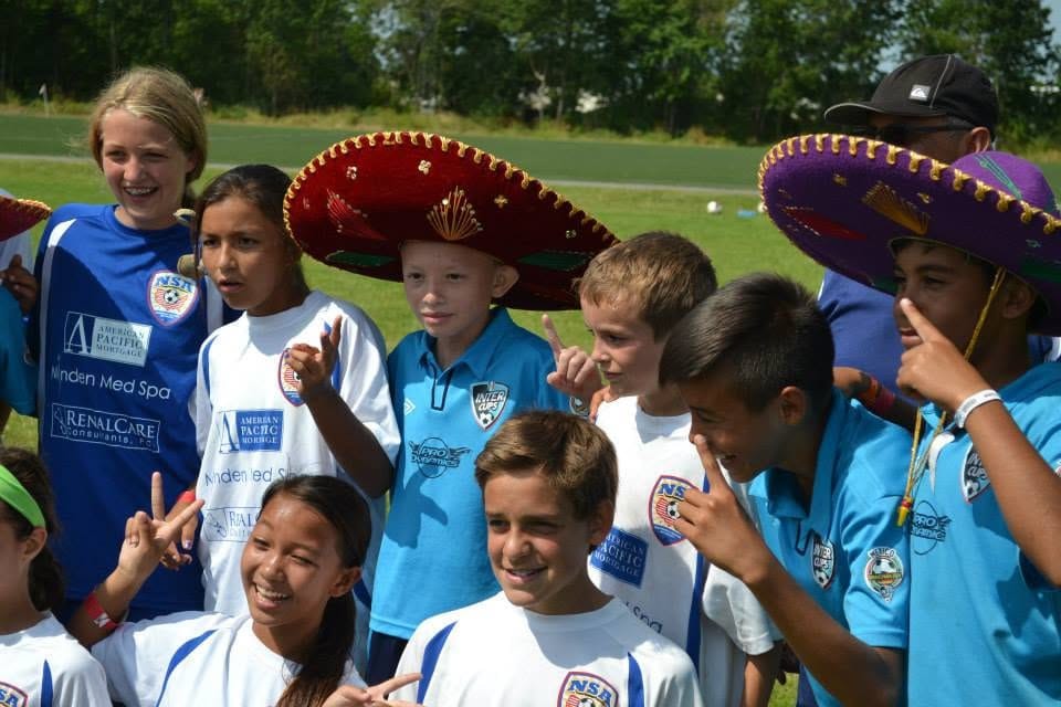 Jugadores de distintos países con sombreros, sonriendo juntos.